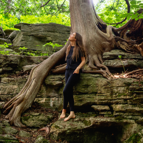 Holistic health practitioner and holistic practitioner in Syracuse NY standing on tree roots in nature, offering functional medicine support in Central New York